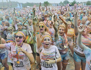 Jeff Lange | The Vindicator  JUNE 13, 2015 - Participants dance and throw colored powder in the air after completing the Color Run 5K race, Saturday morning. Thousands of runners from neighboring areas gathered at the Covelli Centre for the 2015 Color Race in Youngstown.