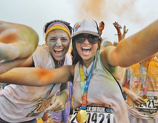 Jeff Lange | The Vindicator  JUNE 13, 2015 - Color Runners Brittany Hart (left) and Taylor Zagorski of Ellwood City, PA point at the camera during the post-race dance party outside of the Covelli Centre in Youngstown, Saturday morning.