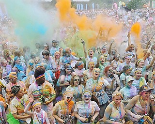 Jeff Lange | The Vindicator  JUNE 13, 2015 - Participants dance and throw colored powder in the air after completing the Color Run 5K race, Saturday morning. Thousands of runners from neighboring areas gathered at the Covelli Centre for the 2015 Color Race in Youngstown.