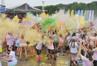 Jeff Lange | The Vindicator  JUNE 13, 2015 - Participants gather to dance and throw colored powder in the air after completing the Color Run 5K race, Saturday morning. Thousands of runners from neighboring areas gathered at the Covelli Centre for the 2015 Color Race in Youngstown.