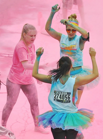 Jeff Lange | The Vindicator  JUNE 13, 2015 - Austintown Fitch senior NHS member Sam Sheely (left) tosses pink powder on participants of the 2015 Color Run in Youngstown, Saturday morning.