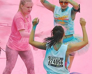 Jeff Lange | The Vindicator  JUNE 13, 2015 - Austintown Fitch senior NHS member Sam Sheely (left) tosses pink powder on participants of the 2015 Color Run in Youngstown, Saturday morning.
