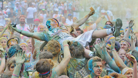 Jeff Lange | The Vindicator  JUNE 13, 2015 - A participant of the 2015 Color Run crowd surfs after running the race, Saturday afternoon at the Covelli Centre in Youngstown.