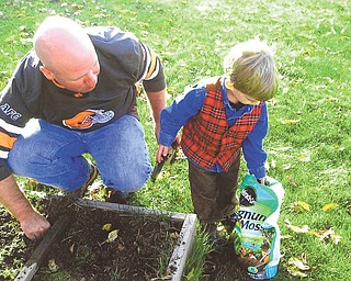 Owen Blanco, 6, says his dad, Chris Blanco, is a good gardener and someday, with his help, Owen will be a good gardener too. They live in Mayfield Heights.