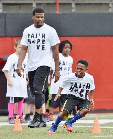 Jeff Lange | The Vindicator  JUNE 20, 2015 - 10 year old Jhordan Peete of Youngstown (right) runs a drill as Chaney graduate and current free agent in the NFL Brad Smith looks on from behind during Smith's football camp held at Stambaugh Stadium in Youngstown, Saturday morning.