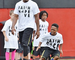 Jeff Lange | The Vindicator  JUNE 20, 2015 - 10 year old Jhordan Peete of Youngstown (right) runs a drill as Chaney graduate and current free agent in the NFL Brad Smith looks on from behind during Smith's football camp held at Stambaugh Stadium in Youngstown, Saturday morning.