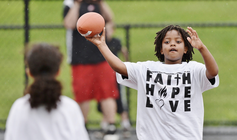 Jeff Lange | The Vindicator  JUNE 20, 2015 - 8 year old Noah Thomas of Austintown (right) looks to make a pass to another child during quarterback drills at Saturday's 8th annual Brad Smith football camp held at Stambaugh Stadium in Youngstown.