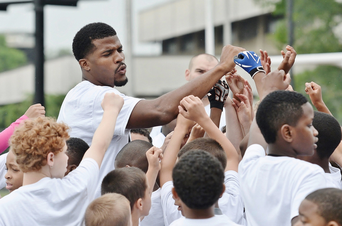 Jeff Lange | The Vindicator  JUNE 20, 2015 - Chaney grad and current NFL free agent Brad Smith (top left) huddles with a group of children before a water break during his 8th annual football camp held at Stambaugh Stadium in Youngstown, Saturday morning.
