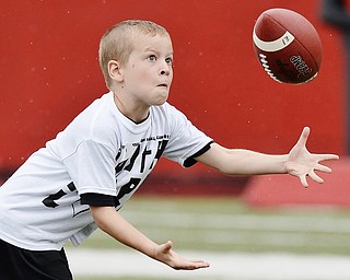 Jeff Lange | The Vindicator  JUNE 20, 2015 - 9 year old Seth Wyatt of Girard eyes down a pass during wide receiver drills at the 8th annual Brad Smith football camp at Stambaugh Stadium, Saturday morning.