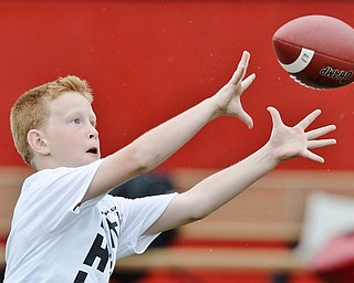 Jeff Lange | The Vindicator  JUNE 20, 2015 - 10 year old Jordan Johnson of Girard looks to catch a pass during wide receiver drills at Saturday's 8th annual Brad Smith football camp at Stambaugh Stadium.