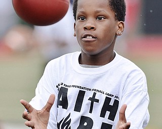 Jeff Lange | The Vindicator  JUNE 20, 2015 - 11 year old Elyzha Dixon of Youngstown eyes down a pass as he prepares to catch it during wide receiver drills at Saturday's 8th annual Brad Smith football camp in Youngstown.
