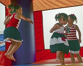 Katie Rickman | The Vindicator.Eva Lemke 1, center, jumps in the bounce house with her twin sisters Emma and Ella 5 at the Austintown Fireworks Celebration July 3, 2015.