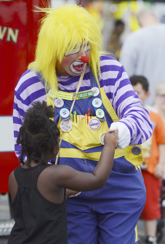 Katie Rickman | The Vindicator.Christina Eskew 4 dances with a clown while waiting in line for a face painting at the Austintown Fireworks Celebration July 3, 2015.