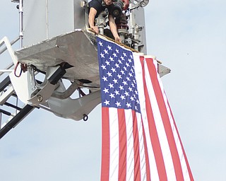 Katie Rickman | The Vindicator.Kelsey Musch of Fire Fighter with Austintown Fire Department straightens the flag and makes sure that it is place at the Austintown Fireworks Celebration July 3, 2015.