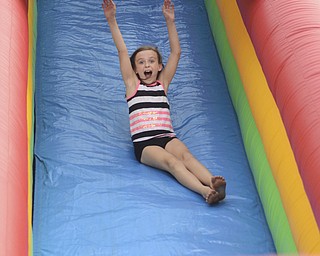 Katie Rickman | The Vindicator.Ava Ekis 8 of Austintown throws her hands in the air as she excitedly slides down a bounce house slide at the Austintown Fireworks Celebration July 3, 2015.