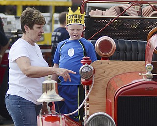 Katie Rickman | The Vindicator.Joe Bickett 6 stands on the side of a vintage firetruck as Bredna Fraser of Austintown points to the truck at the Austintown Fireworks Celebration July 3, 2015.