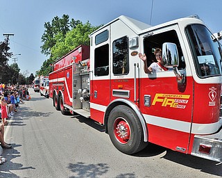 Jeff Lange | The Vindicator  JULY 4, 2015 - Spectators look on as a member of the Canfield Fire Department waves during this year's Fourth of July parade in Canfield, Saturday morning.