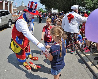 Jeff Lange | The Vindicator  JULY 4, 2015 - Member of Aut Morri Grotto, Jesse Boles of Mineral Ridge also known as Pokey (left) hands candy out to children during the 4th of July parade in Canfield, Saturday morning.