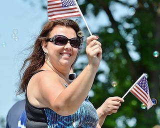 Jeff Lange | The Vindicator  JULY 4, 2015 - Owner of Stage Left Dance Academy in Canfield Kim Lisowski waves the Stars and Stripes at the crowd as she passes by on her company sponsored float during Saturday's 4th of July parade in Canfield.
