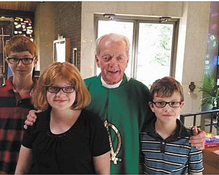 SPECIAL TO THE VINDICATOR
The Rev. Timothy O’Neill, “Father Tim” to students at St. Patrick School in Hubbard, said his last Mass on June 28. He blessed the students with learning, laughter, understanding and faith, participated in many special activities at the school and always had a story to tell. Members of the Yesh family, who are students at St. Patrick School, enjoyed a few minutes with the priest before his last Mass. From left are Simon Yesh, Zoe Yesh, Father O’Neill and Joey Yesh.