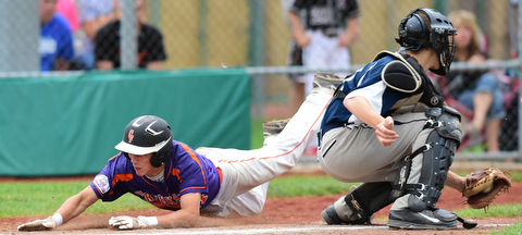 STRUTHERS, OHIO - JULY 8, 2015: Don Drummond #17 of Creekside slides across home plate to score a run beating the tag from Coleman Stauffer #20 of Baird Brothers in the 4th inning during Wednesday nights Little B championship game at Cene Park.