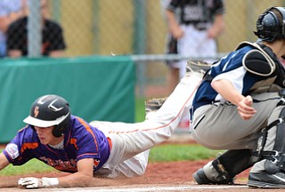 STRUTHERS, OHIO - JULY 8, 2015: Don Drummond #17 of Creekside slides across home plate to score a run beating the tag from Coleman Stauffer #20 of Baird Brothers in the 4th inning during Wednesday nights Little B championship game at Cene Park.