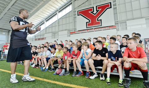 Jeff Lange | The Vindicator  JULY 11, 2015 - Former linebacker in the NFL Tim Johnson (left) speaks to children during his annual football camp at the WATTS center in Youngstown Saturday morning.