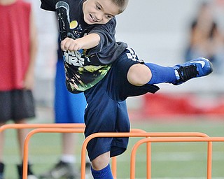 Jeff Lange | The Vindicator  JULY 11, 2015 - 8 year old Timothy Baker of Niles hops over hurdles during drills at Saturday's Tim Johnson Football Camp at YSU.
