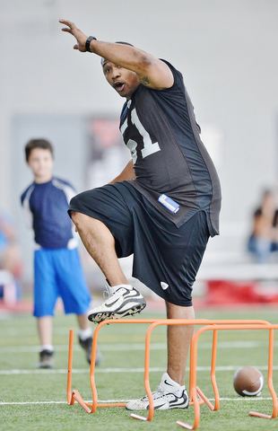 Jeff Lange | The Vindicator  JULY 11, 2015 - Former NFL player and YSU grad Tim Johnson demonstrates how to properly run a drill during his annual football skills camp at YSU Saturday morning.