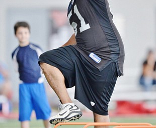Jeff Lange | The Vindicator  JULY 11, 2015 - Former NFL player and YSU grad Tim Johnson demonstrates how to properly run a drill during his annual football skills camp at YSU Saturday morning.