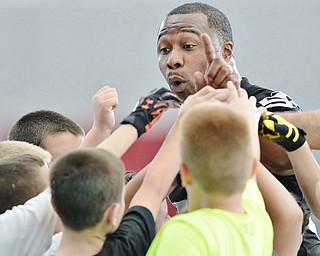 Jeff Lange | The Vindicator  JULY 11, 2015 - Former NFL player and YSU grad Tim Johnson (facing) huddles up with children in between drills at his football skills camp at YSU Saturday morning.