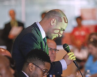        ROBERT K. YOSAY  | THE VINDICATOR..Joe Schiavoni .. reads the bill ( it was on a projector - those are letters across hisf face)..State Sen. Joe Schiavoni  state Rep. Michele-Lepore-Hagan, Mayor John A. McNally will hosted a meeting  William Holmes McGuffey Elementary School to discuss the Youngstown plan legislated for city schools recovery.  ..
