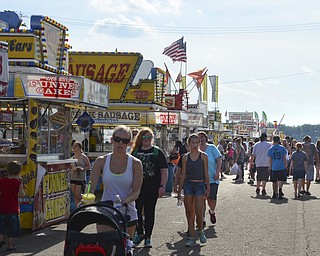 Katie Rickman | The Vindicator.Fairgoers walk the blacktopped walkways at the Trumbull County Fairgrounds on Saturday, July 18, 2015.