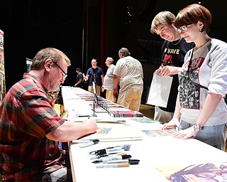 WARREN, OHIO - JULY 18, 2015: Comic book artist Michael Golden signs some autographs for Emily and Adam Hughes of Warren Saturday afternoon at Packard Music Hall during All-Americon 6. DAVID DERMER | THE VINDICATOR.