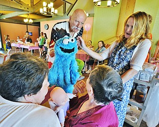 Jeff Lange | The Vindicator  JULY 18, 2015 - Canton Puppeteer Chuck Zerger (center) works a Cookie Monster puppet as Quality of Life Director at Signature Healthcare Maureen McCarty (right), Dorothy Spitler (bottom right) and Dorothy's daughter Sheila Persino look on during Saturday morning's Sweet Pea Tea held at Signature Healthcare in Warren.