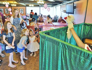 Jeff Lange | The Vindicator  JULY 18, 2015 - Children look on in excitement as Chuck Zerger of Canton (right) puts on a puppet show during Saturday morning's Sweet Pea Tea party held at Signature Healthcare in Warren.