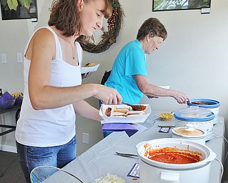 Jeff Lange | The Vindicator  JULY 18, 2015 - Kristal Ruggles (left) of Ravenna and her grandmother Joanne Davenport of Streetsboro load up their hotdogs with toppings during Saturday's Hot Diggity Dog fundraising event held at Lil Paws Winery in Lake Milton.
