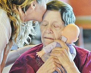 Jeff Lange | The Vindicator  JULY 18, 2015 - Quality of Life Director at Signature Healthcare Maureen McCarty (left) plants a kiss on the forehead of resident Dorothy Spitler as she embraces her babydoll which she named Sweet Pea during Saturday morning's Sweet Pea Tea Party held at Signature Healthcare in Warren. Spitler has been a resident of the healthcare center for thirteen months and was the inspiration for the creation of the event.