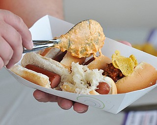 Jeff Lange | The Vindicator  JULY 18, 2015 - A visitor of Lil Paws Winery puts cheese on his hotdogs during Legacy Dog Rescue's fundraising event "Hot Diggity Dog Day" held at the winery in Lake Milton, Saturday afternoon.