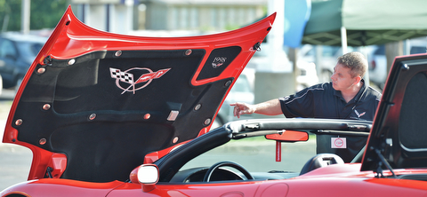 Jeff Lange | The Vindicator  JULY 19, 2015 - Anthony Manolio of Canfield admires the hood of a Corvette during the Mahoning Valley Corvettes Club car show in Austintown on Sunday.