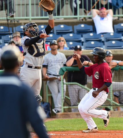 NILES, OHIO - JULY 22, 2015: Silento Sayles #9 of the Scrappers scores a run while catcher Jake Hernandez #35 of the Yankees leaps in the air to catch the baseball in the 3rd inning of Wednesday nights game at Eastwood Field. DAVID DERMER | THE VINDICATOR