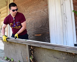 YOUNGSTOWN, OHIO - JULY 25, 2015: Alec Marsili of Alliance removes a piece of debris outside of an abandoned home on Park Avenue Saturday morning during a YSU Wick Park neighborhood clean up. DAVID DERMER | THE VINDICATOR
