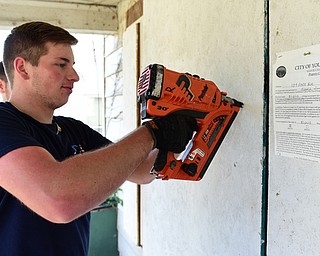 YOUNGSTOWN, OHIO - JULY 25, 2015: Nick Diloreto of East Liverpool nails a board to the doorframe of an abandoned home on Park Avenue Saturday morning during a YSU Wick Park neighborhood clean up. DAVID DERMER | THE VINDICATOR