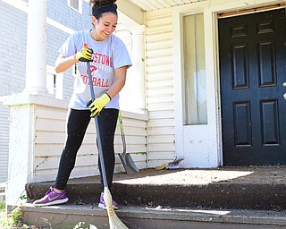 YOUNGSTOWN, OHIO - JULY 25, 2015: Gianna Marinucci of Boardman sweeps away weeds and small debris outside of an abandoned home on Park Avenue Saturday morning during a YSU Wick Park neighborhood clean up. DAVID DERMER | THE VINDICATOR