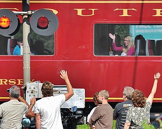 Jeff Lange | The Vindicator  JULY 25, 2015 - A passenger aboard the Nickel Plate Road No. 765 waves to onlookers that had gathered at the railroad crossing on State Route 304 in Hubbard as it passes through on it's way to Ashtabula on Saturday morning.