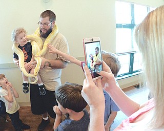 Jeff Lange | The Vindicator  JULY 26, 2015 - Lee Withrow and his two-year-old son Anthony have their picture taken with an Albino Boa Constrictor as Lee's wife Deanna (right) snaps the photo with her phone and his daughter three-year-old daughter Leslie (bottom left) looks on in terror, Sunday morning at Mill Creek MetroParks Farm in Canfield during the reptile exhibit.