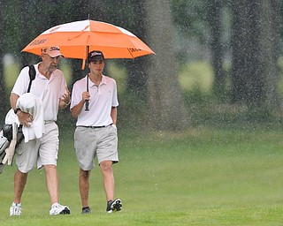 Jeff Lange | The Vindicator  JULY 26, 2015 - Anthony Granziano of Girard (right) and personal coach John Perry of Houston, Texas walk the course in a downpour during Sunday afternoon's Greatest Golfer of the Valley Junior championship held at Avalon Lakes Golf & Country Club in Howland.