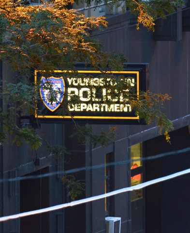 The Youngstown Police Department sign lights up the darkening road on Boardman Street.