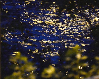 The Mahoning River flows under the Marshall Street bridge, the darkening blue sky is reflected in the water.