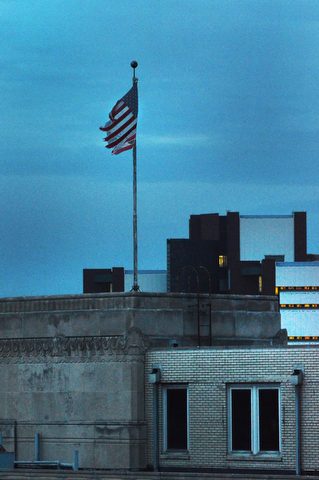 A flag blows in the wind on top of the YBI building which once was The Vindicator.